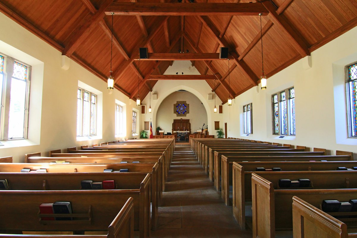 Sunlit sanctuary with wooden pews
